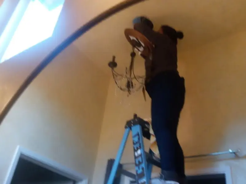 Electrician installing a chandelier in a Franklin residence